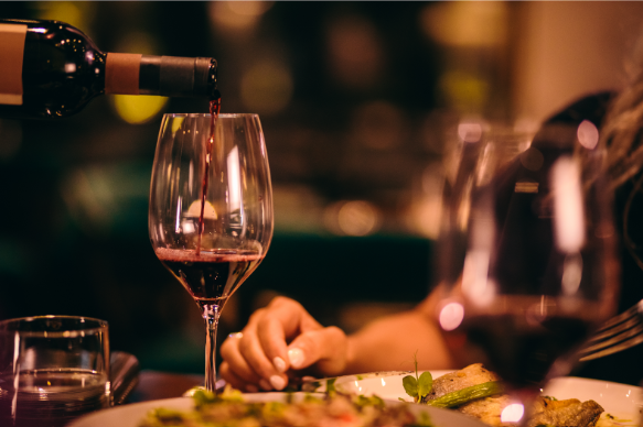 Someone pouring a glass of wine at a fancy restaurant